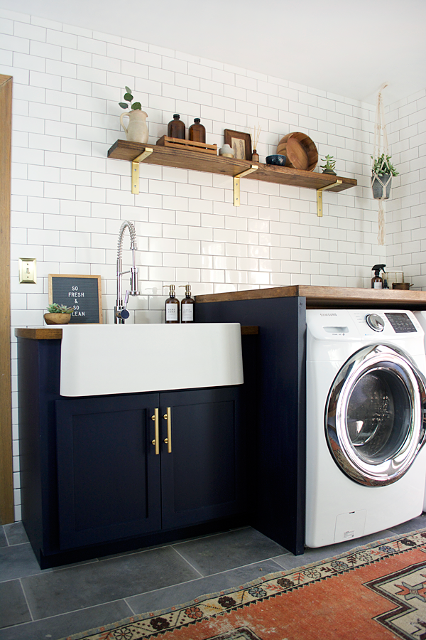 modern navy laundry room with subway tile and open shelf