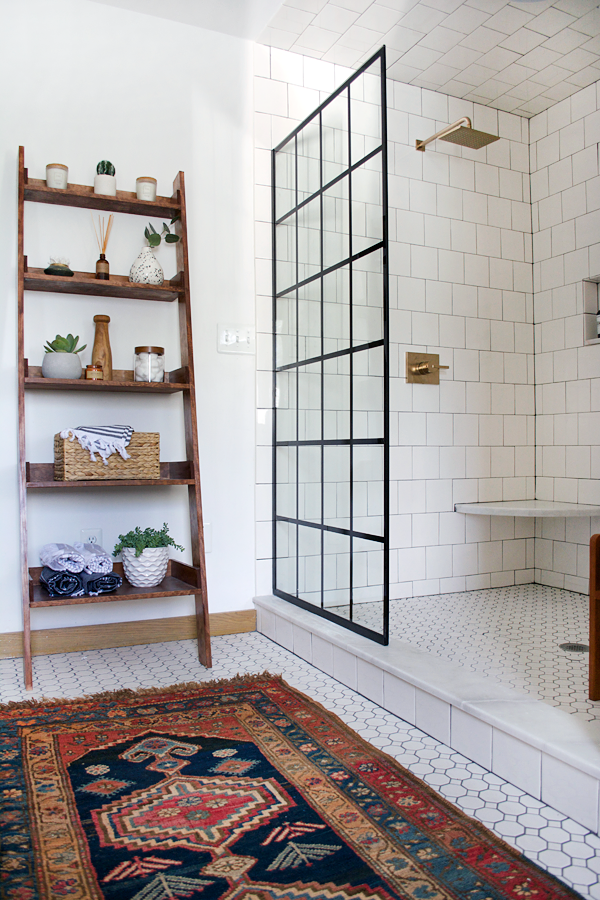 black shower panel partition with brass fixtures