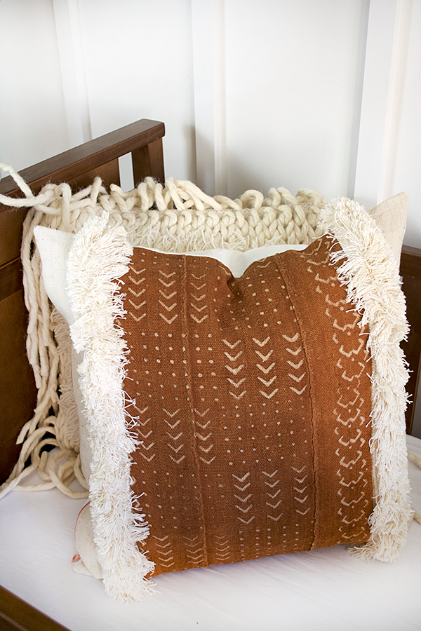 rust mudcloth pillow in a nursery