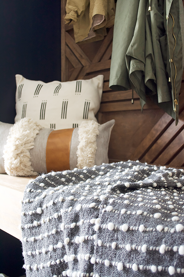 pillows and blanket on a floating bench in mud room