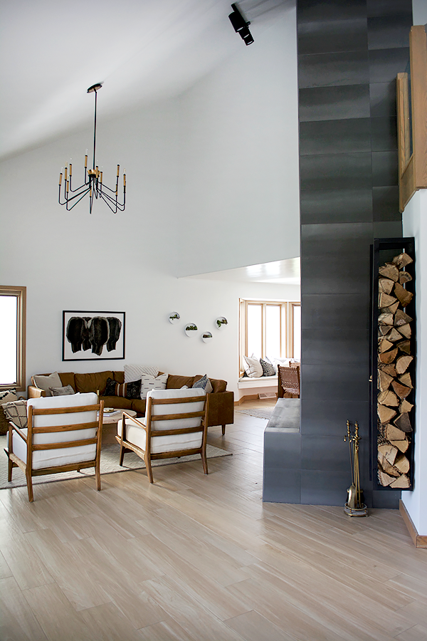 Floating firewood rack next to floor to ceiling fireplace