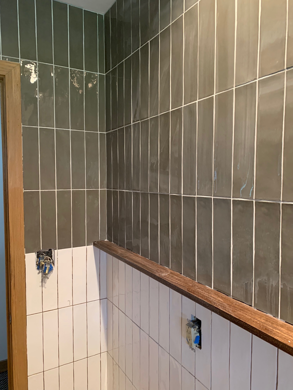 Green tile with white grout in the bathroom
