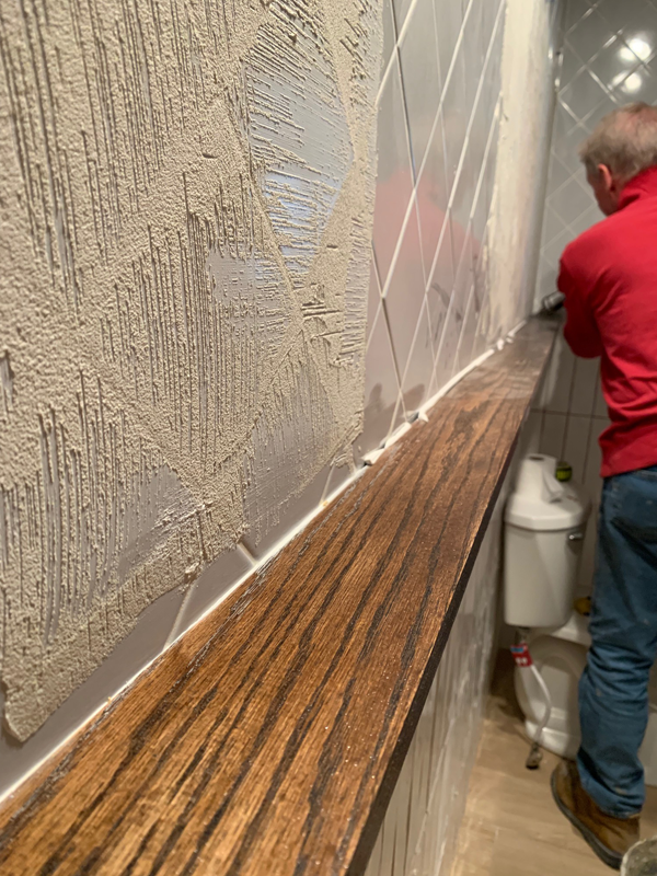 Installing a shelf between tile in a bathroom